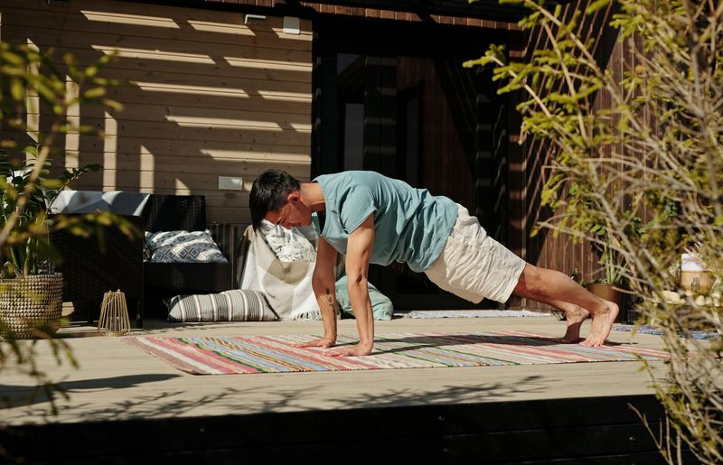 Man doing a plank exercise with perfect form in a bright room.